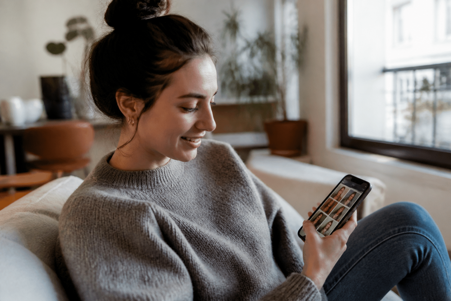 Personne souriante regardant ecran smartphone avec profils dates visibles