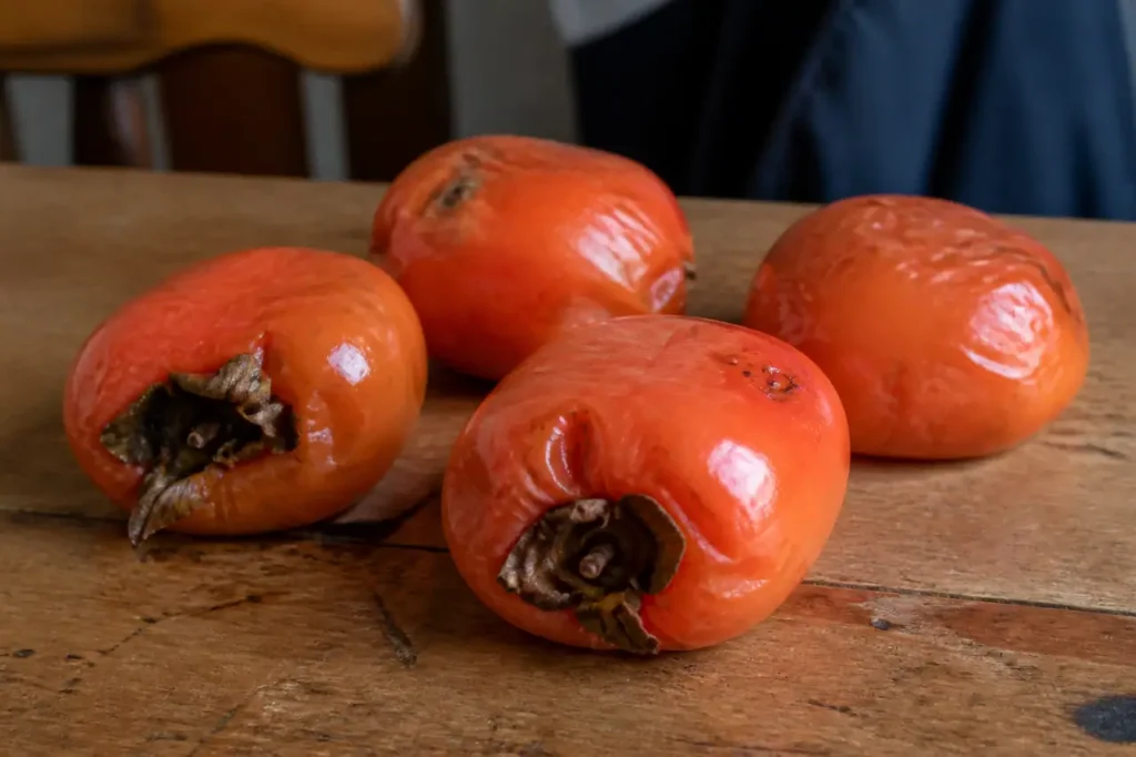 Kakis orange bien mous sur une table en bois