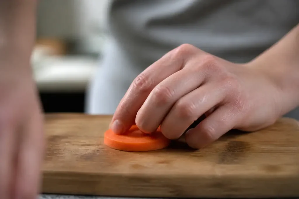 Mains tenant une rondelle orange sur planche en bois